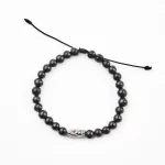 Pulsera con cuentas de barro negro y dije plateado. Diferentes modelos