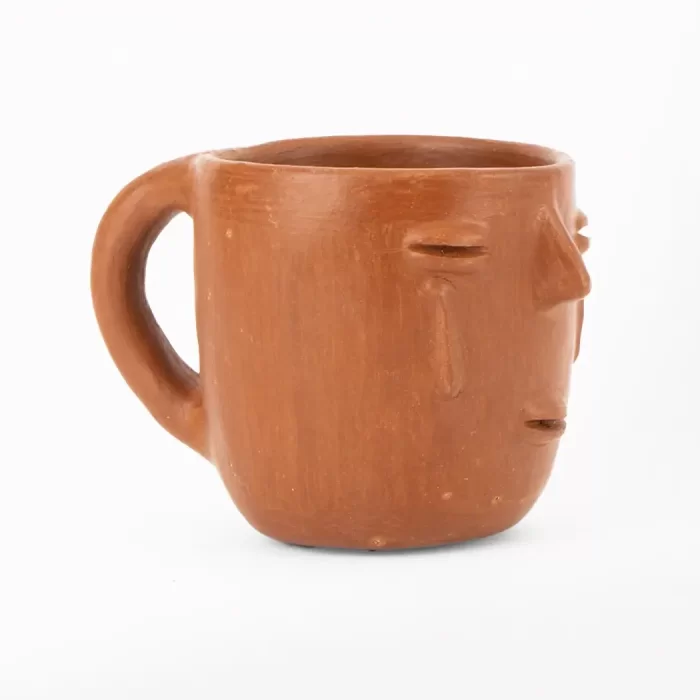 Taza de barro rojo con diseño de cara