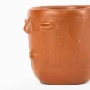 Taza de barro rojo con diseño de cara