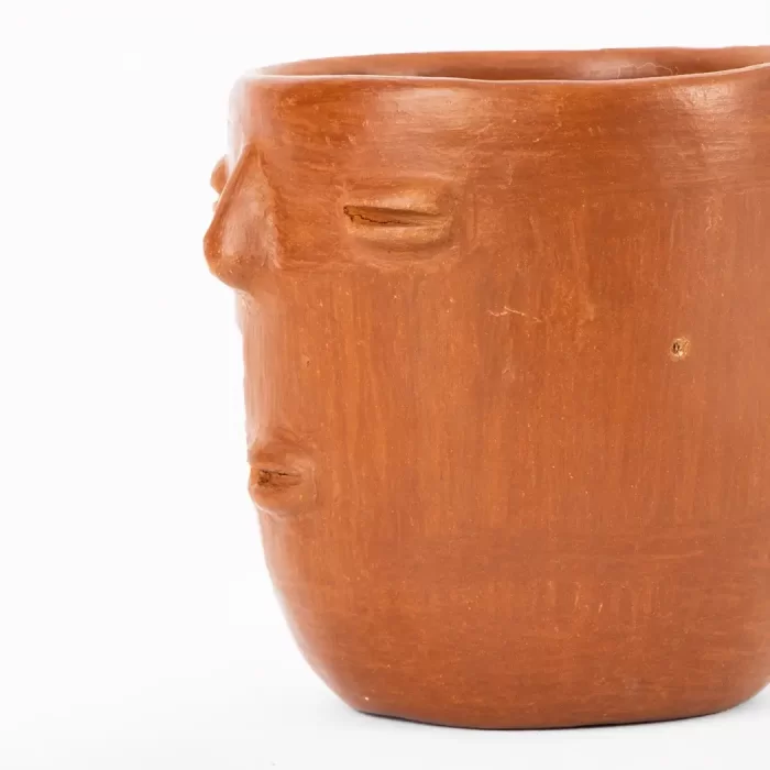 Taza de barro rojo con diseño de cara