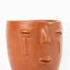 Taza de barro rojo con diseño de cara