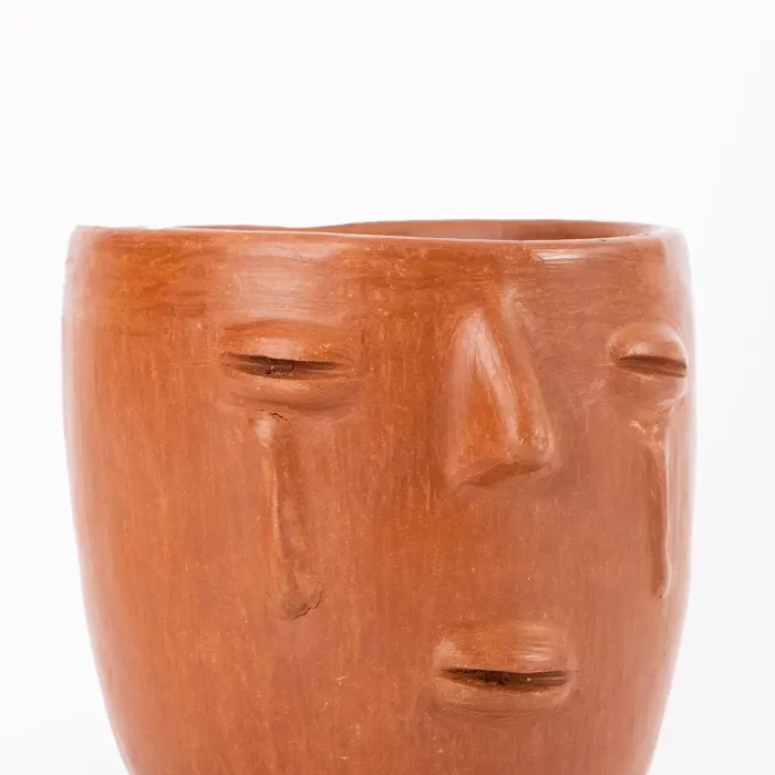 Taza de barro rojo con diseño de cara